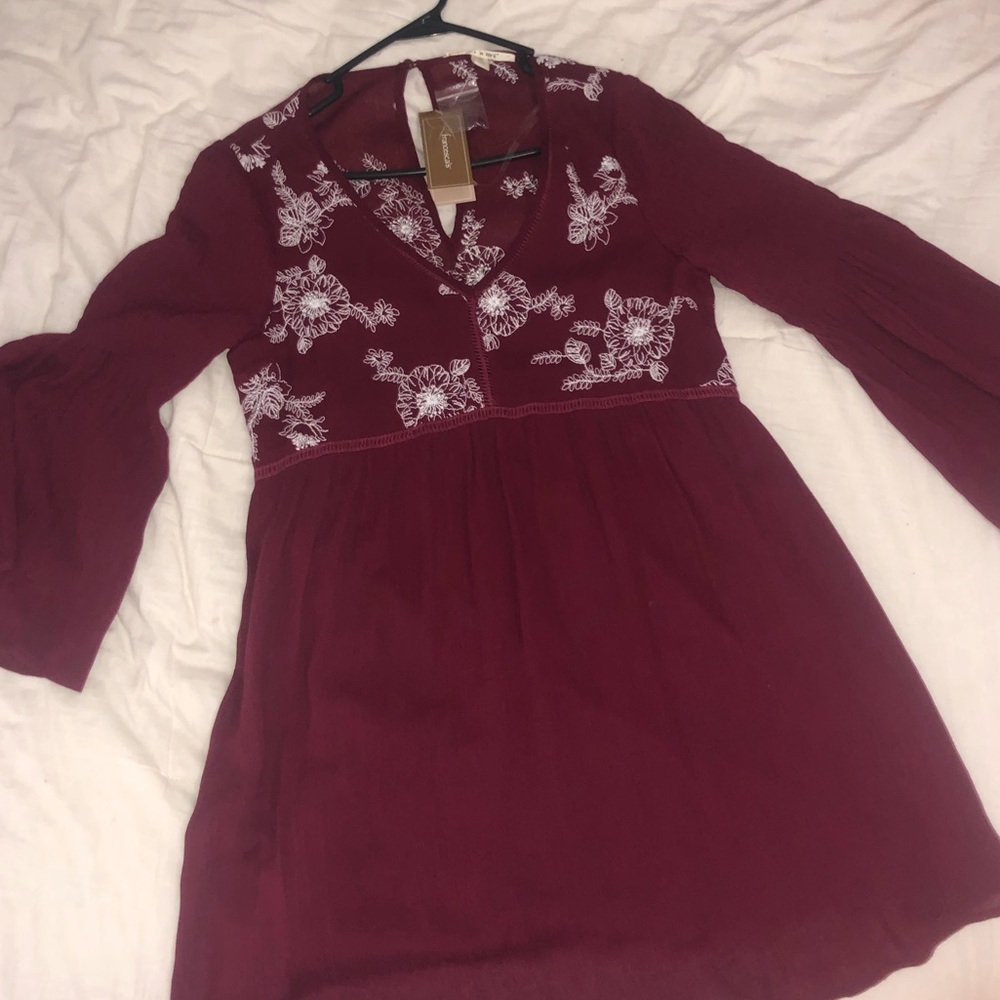 a maroon dress with white stitched flowers